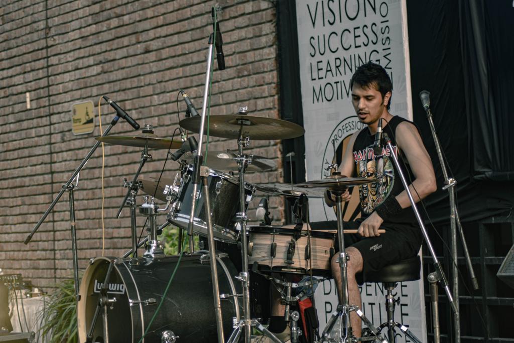 Zubin Justin playing drums live on stage.